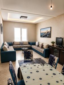 a living room with a couch and a table at Résidence Haute Standing Corniche in Martil