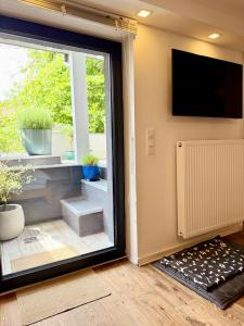 ein Zimmer mit einer Glasschiebetür und einem Fenster in der Unterkunft Teddis Traubing in Tutzing
