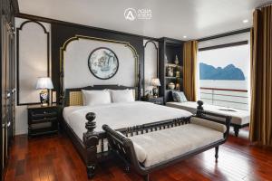 a bedroom with a large bed and a bench at Aqua of the Seas Cruise in Ha Long