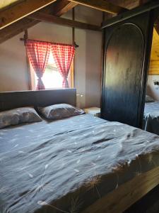 a large bed in a room with a window at Vikendica Stanković in Šipovo