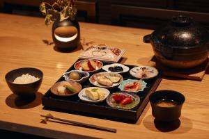 a tray of food on a wooden table with sushi at Trunk House in Tokyo