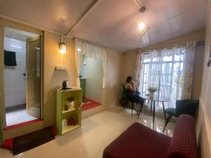 a woman sitting at a table in a living room at GD's Homestay in Shillong