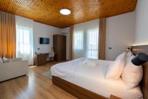 a bedroom with a large bed with white pillows at Hotel Aleks in Shkodër