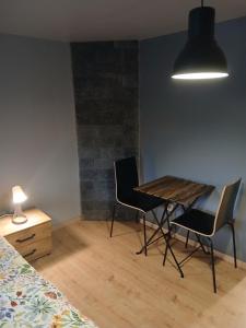 a room with a table and two chairs and a lamp at Le petit Broux in Aywaille