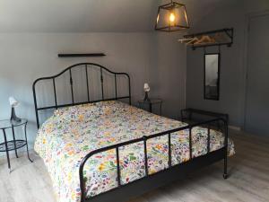 a bedroom with a bed with a floral comforter at Le petit Broux in Aywaille