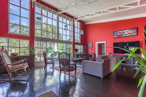 a living room with red walls and a table and chairs at Villas ti creole nogent in Sainte-Rose
