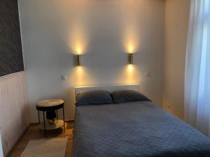 a bedroom with a bed and two lights on the wall at Rohu Külaliskorter vanalinnas in Kuressaare