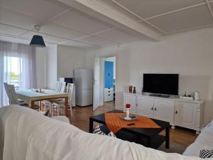 a living room with a couch and a table with a tv at Manus Ferienwohnung in Brevik