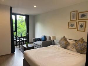 a bedroom with a bed and a couch and a chair at The Base Central Phuket-B2-Y9B in Ban Rangeng +36 photos