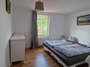 a bedroom with a bed and a window at Manus Ferienwohnung in Brevik