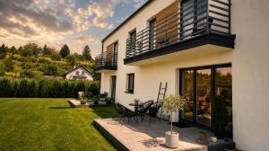 a house with a patio and a lawn at Śpij w Kudowie Apartament i pokoje gościnne in Kudowa-Zdrój