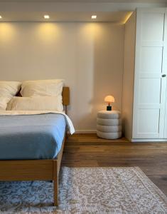 ein Schlafzimmer mit einem Bett und einem Tisch mit einer Lampe in der Unterkunft Teddis Traubing in Tutzing