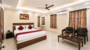 a bedroom with a bed and a desk and a chair at Hotel MountView Comforts in Tirupati +76 photos