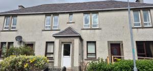 a large brick house with a white door at Flat 21 - 1st floor - Westview Terrace, Stornoway in Stornoway