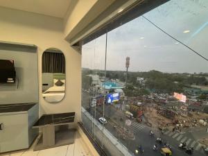 a room with a window with a view of a city at Hotel Planet Lake in Ahmedabad