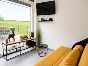 a living room with a couch and a tv on a wall at Gîte La Petite Villette in Fronville