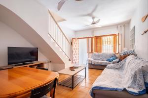 a living room with a couch and a tv at Bungalow Barlovento Playa in Arenales del Sol