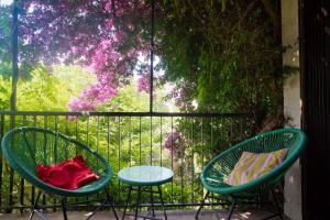 two chairs and a table on a balcony with flowers at Maison Serra - Jacuzzi, Sauna in Collioure