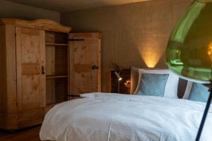 a bedroom with a white bed and a wooden cabinet at Lodge 53 in Breitenwang