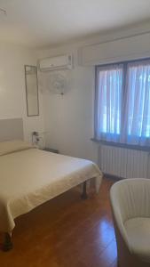a bedroom with a bed and a chair and a window at Vacanza nella Natura in Punta Ala