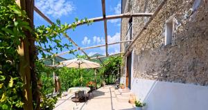 a patio with a table and an umbrella at Casale Gelsi in Maiori