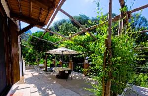 a patio with an umbrella and a table and chairs at Casale Gelsi in Maiori