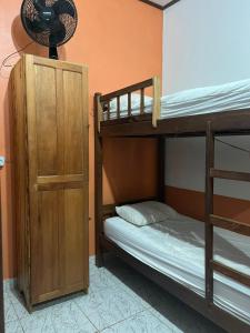 a bedroom with two bunk beds and a fan at Hostel Pousada do Tapajós in Alter do Chao