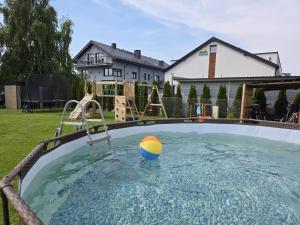 a pool with a ball in the water in a yard at Baltic Harmony Villas - Grzybowo in Grzybowo