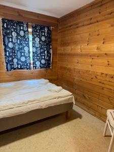 a bedroom with wooden walls and a bed and a window at Trolltunga byFjord in Odda +1 photo