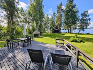 a deck with tables and chairs and a gazebo at Ainola Cottage in Alapitkä
