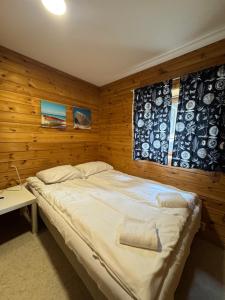 a bedroom with a large bed with a wooden wall at Trolltunga byFjord in Odda