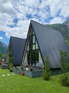 a large house with a gambrel roof at Monark Villas in Theth