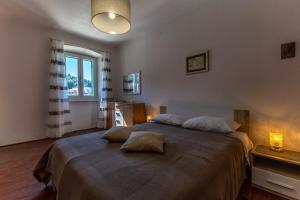 a bedroom with a large bed with two pillows on it at Apartment Mare - Beachfront in Rabac