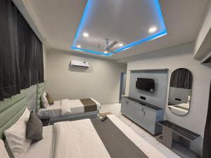 a hospital room with a bed and a tv at Hotel Planet Lake in Ahmedabad