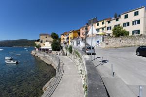 a street next to a body of water with buildings at Apartment Mare - Beachfront in Rabac