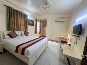 a bedroom with a large bed and a television at Hotel Roselle Heights in Jaipur
