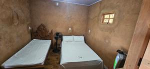a bedroom with two beds and a window at Recanto do Baru in Pirenópolis