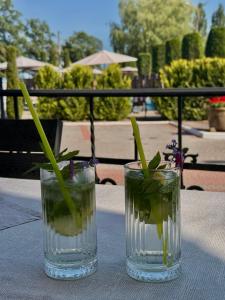 two glasses sitting on a table with flowers in them at In hotel in Kamianets-Podilskyi