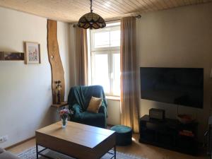 a living room with a chair and a television at Rohu Külaliskorter vanalinnas in Kuressaare
