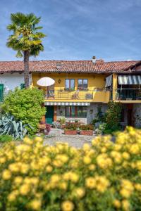 a yellow house with a palm tree in front of it at Cà 'd Langa B&B in Treiso