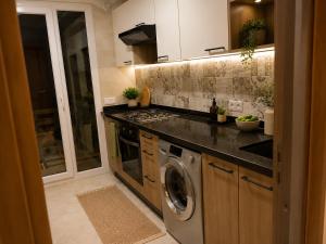 a kitchen with a stove and a washing machine at Résidence Haute Standing Corniche in Martil