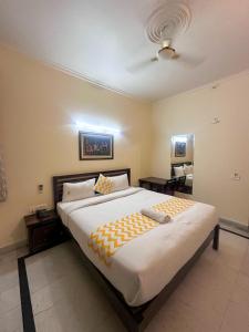 a bedroom with a large bed and a ceiling at Hotel Roselle Heights in Jaipur