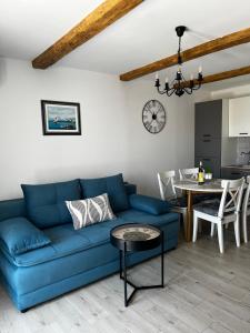 a living room with a blue couch and a table at Charming apartment piccolo paradiso in Vlašići