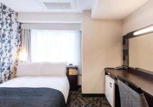 a hotel room with a bed and a window at APA Hotel Kyoto Eki Horikawadori in Kyoto