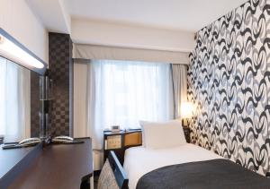 a hotel room with a bed and a desk at APA Hotel Kyoto Eki Horikawadori in Kyoto