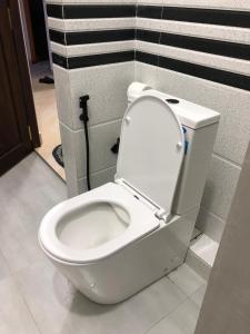a white toilet with the lid up in a bathroom at Unawatuna Backpacker Lodge in Unawatuna