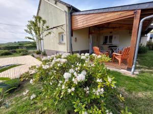 a house with a porch with chairs and flowers at La Maison Rose in Mhère