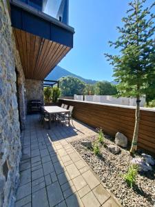 a patio with a table and a tree on a building at Chalet Johannes in Liptovský Ján