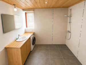 a bathroom with a sink and a washing machine at Kalvi tee Puhkemaja in Viru-Nigula