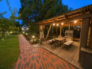 a wooden deck with a table and a wooden pergola at Kalvi tee Puhkemaja in Viru-Nigula +5 photos